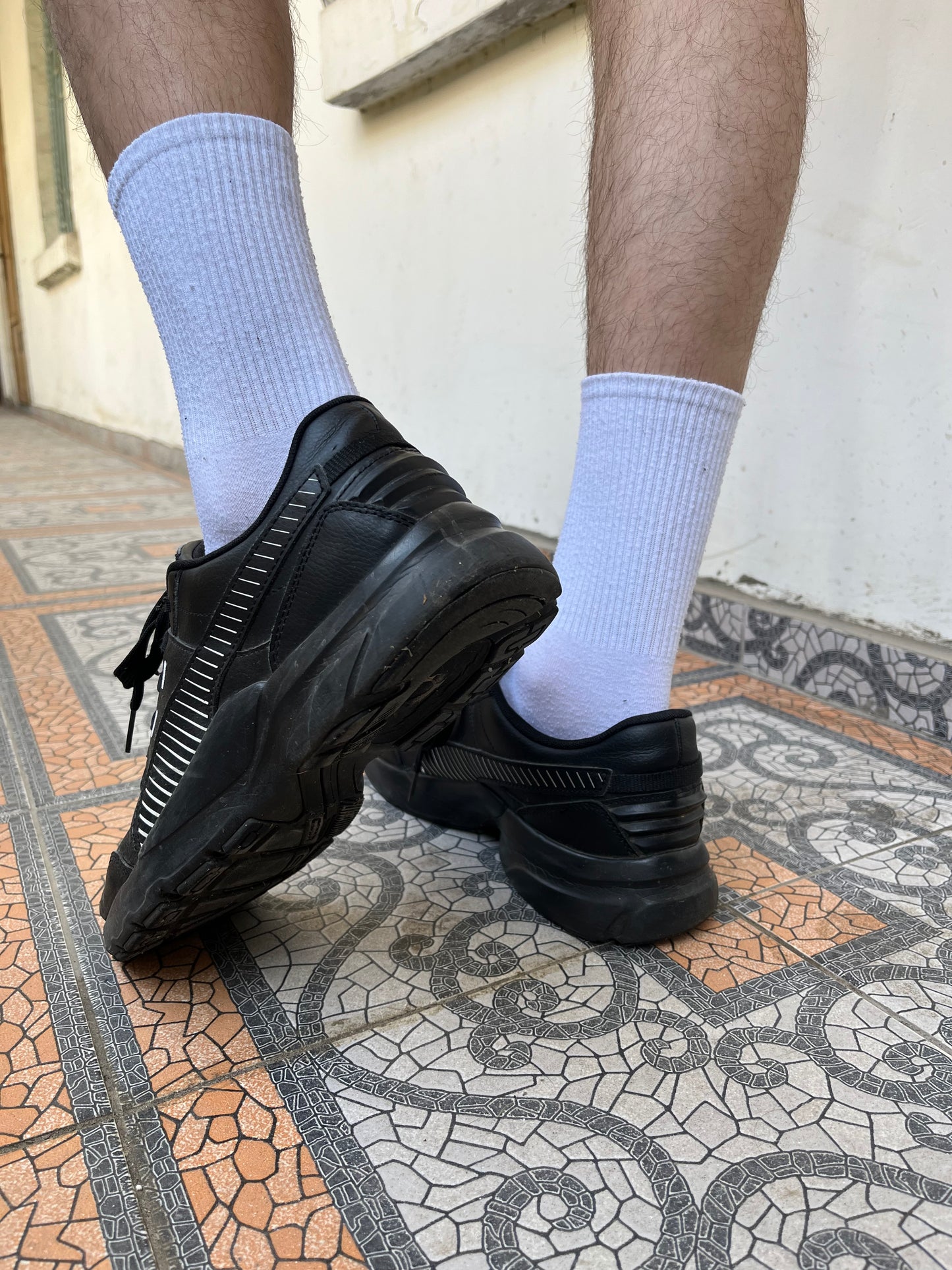 Black Puma trainers with white stripes